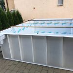 Na plastovom bazéne je umiestnená konštrukcia z dreva, ktorá je určená na jeho prepravu.